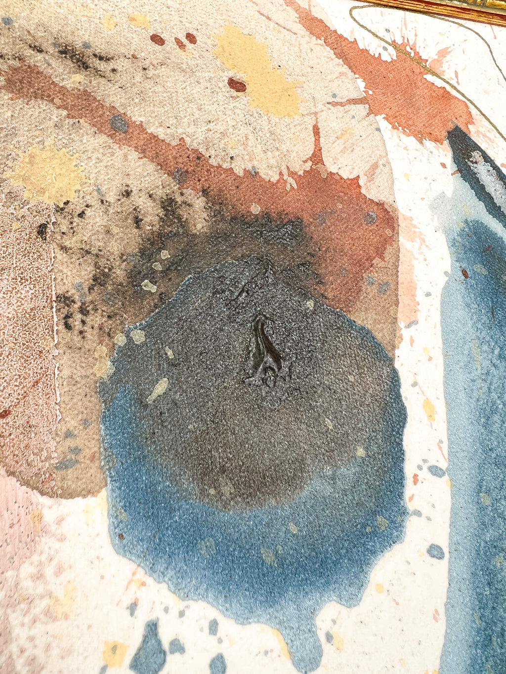 Abstract art with splashes of blue, brown, and beige on a raw canvas background