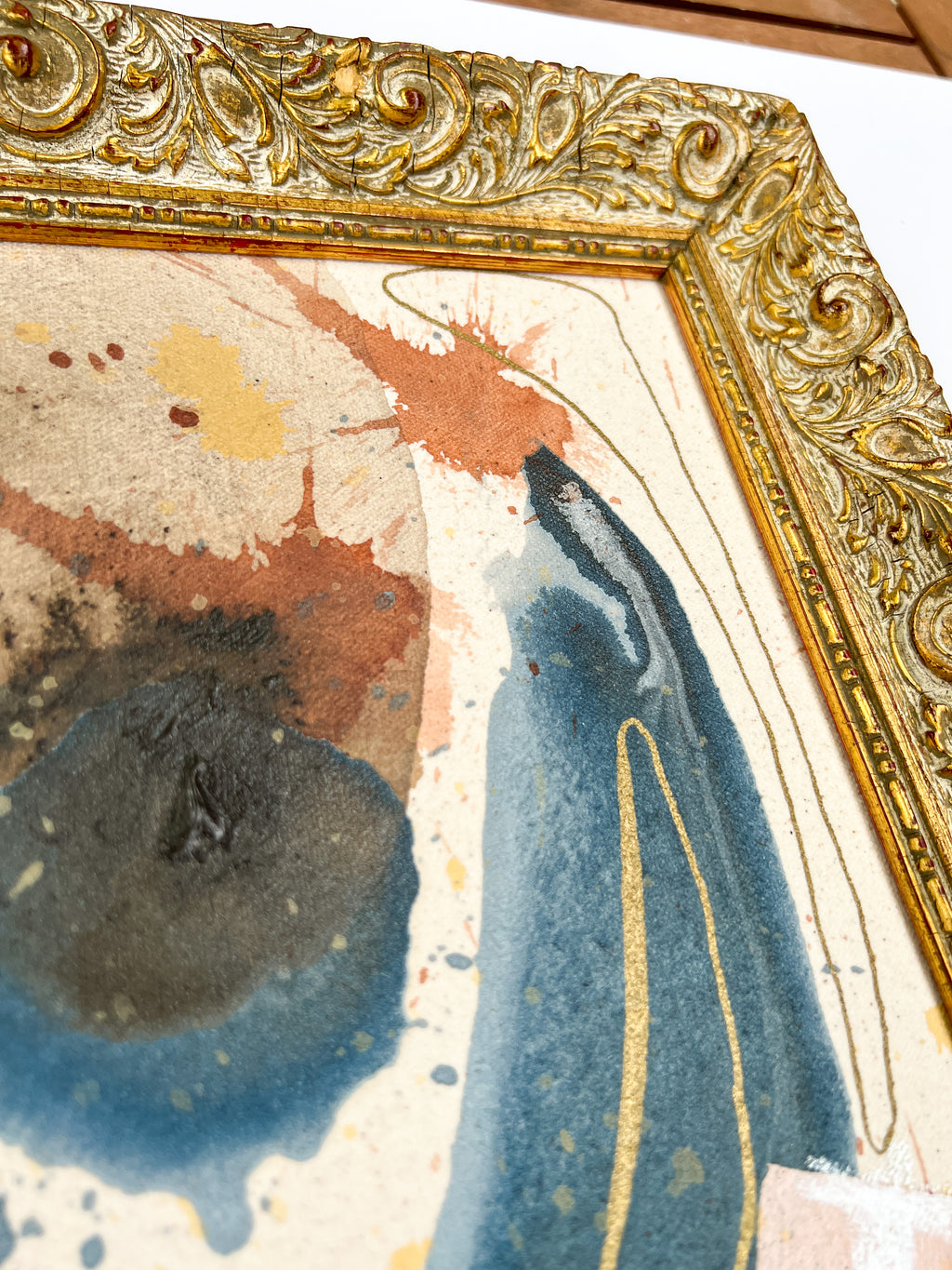 Close-up of a painting with a decorative gold frame by New Orleans artist Maggie Callan