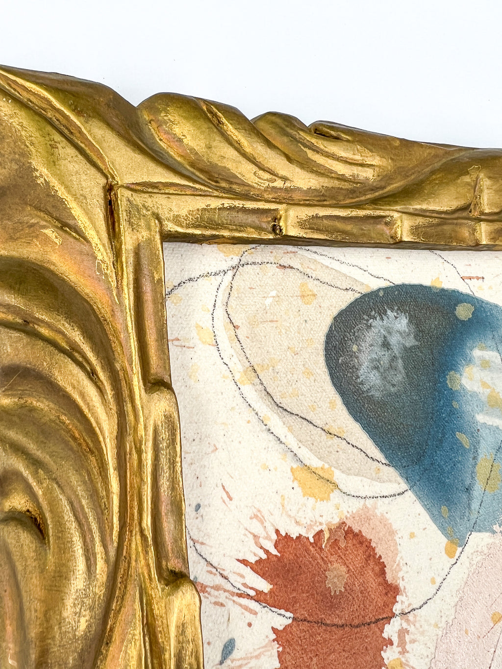 Close-up of a decorative gold frame with artistic elements on a white background