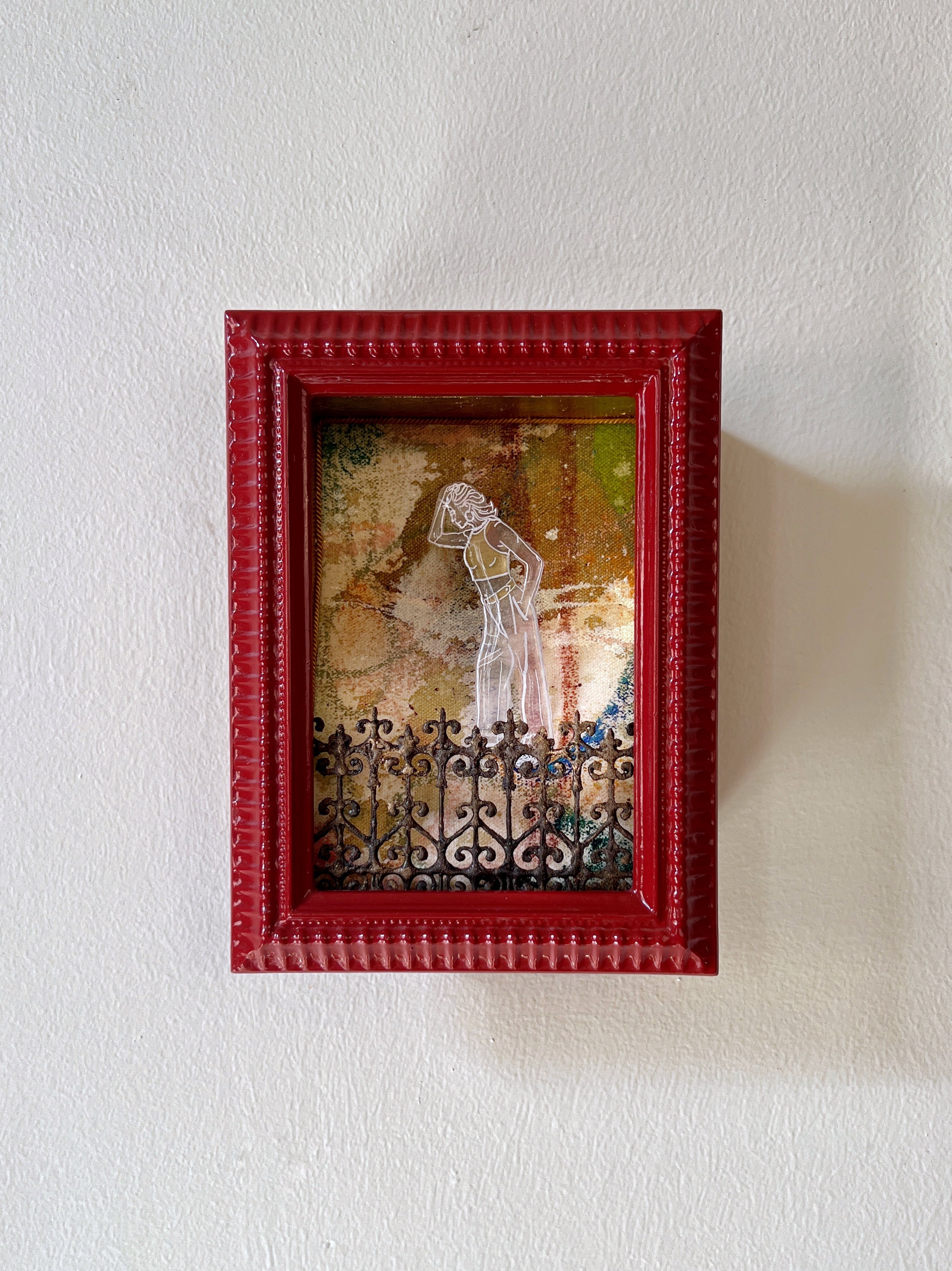 Decorative shadow box with a red frame on a white wall