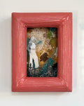 Framed artwork with a colorful background and a figure inside, on a light gray background