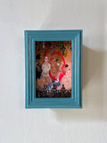 Framed artwork with a colorful design on a white wall