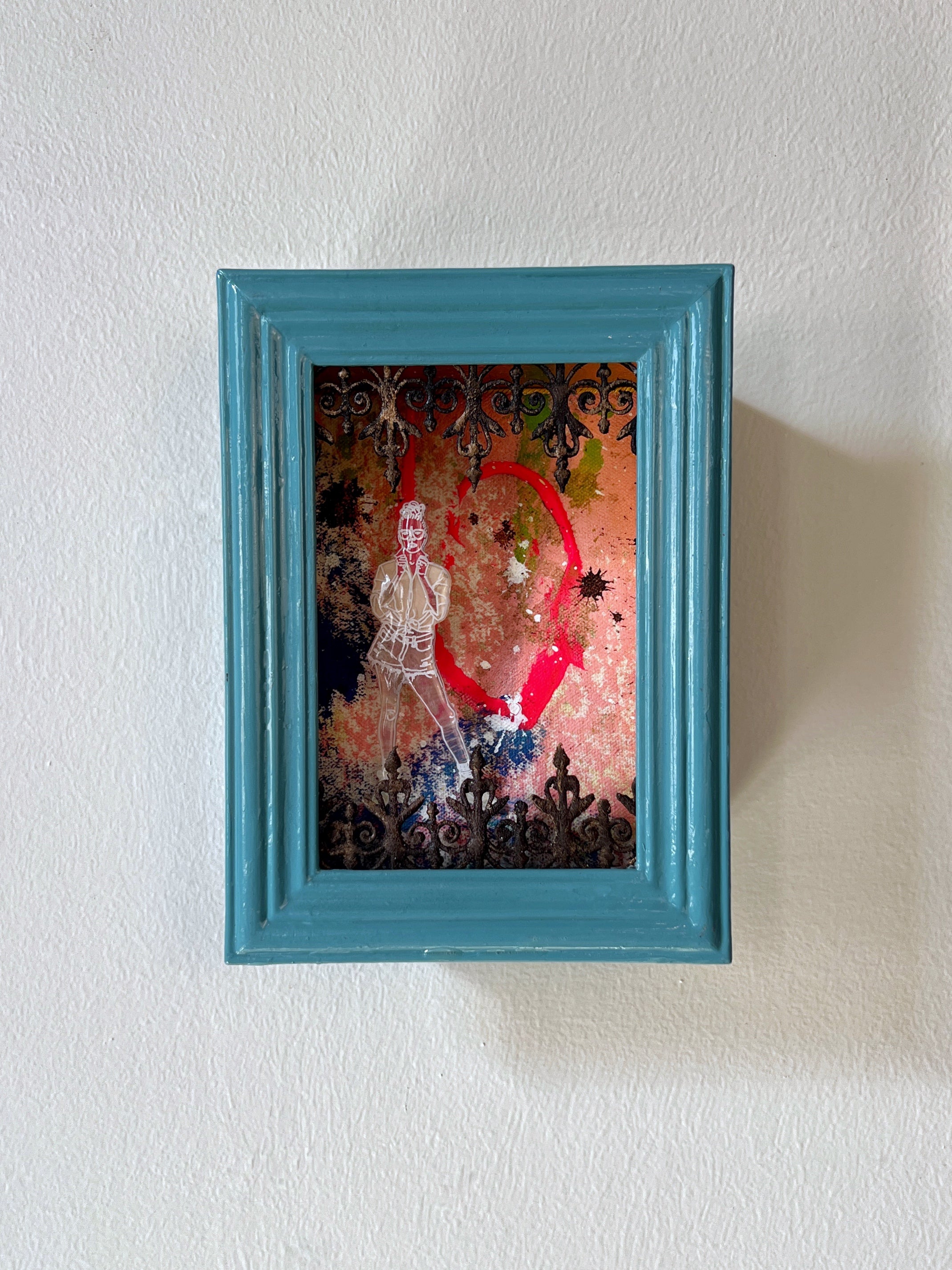 Framed artwork with a colorful design on a white wall