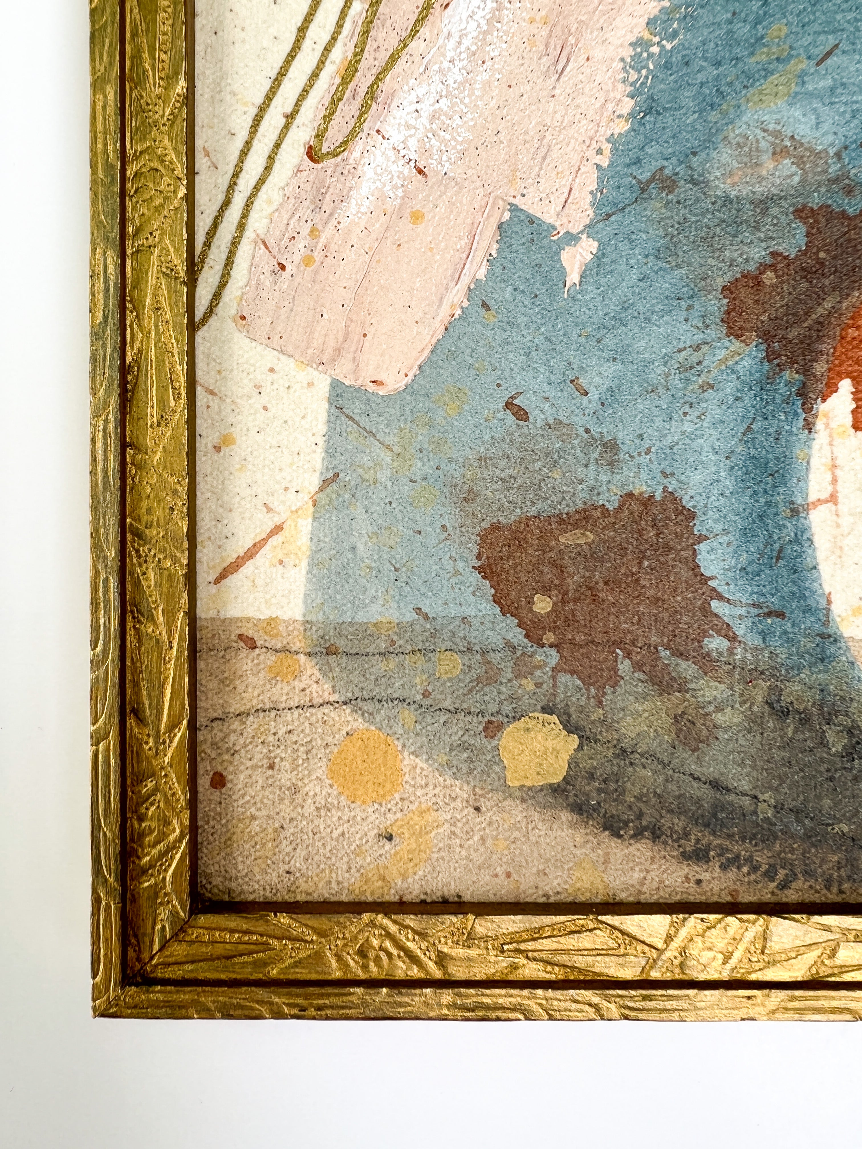 Close-up of a textured painting with gold frame on a white background